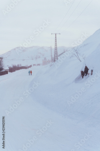 a group of people follow a hill heavily covered with snow during a trip along the polar tundra in winter