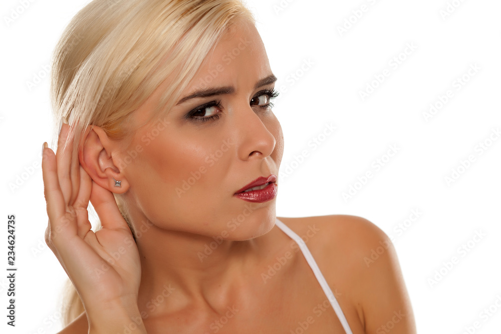 Portrait of beautiful blonde woman on white background with palm behind her ear Portrait of beautiful blonde woman on white background with palm behind her ear