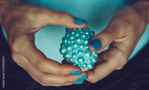 Female hands hold decorated Easter egg. The concept of turquoise color