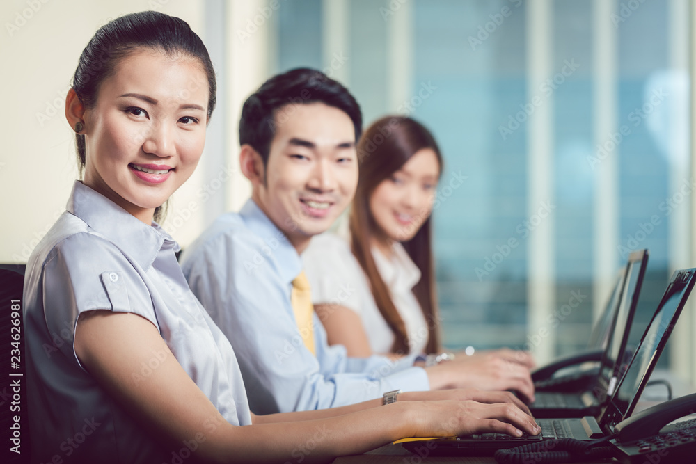 Portrait of smiling businesspeople with laptop at workplace Portrait of smiling businesspeople with laptop at workplace