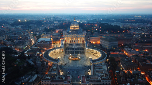 Aerial drone night view of Saint Peter's square in front of world's largest church - Papal Basilica of St. Peter's, Vatican -an elliptical esplanade created in the mid seventeenth century, Rome, Italy
