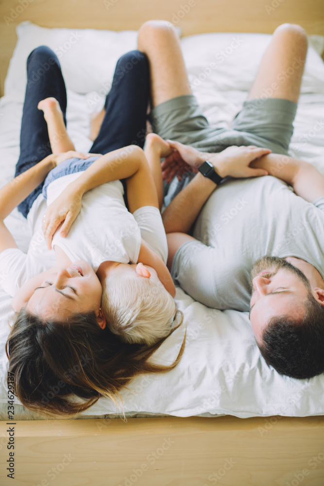 Cheerful family having fun together lying on a bed Cheerful family having fun together lying on a bed