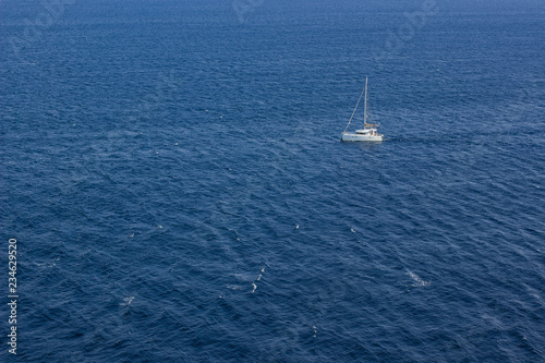 summer holidays concept of sea waves surface and small white yacht from above aerial shot, copy space  © Артём Князь