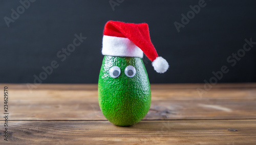 Christmas avocado. avocado in christmas hat. holidays concept