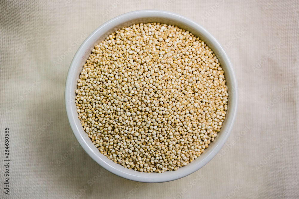 Quinoa in white cup. Raw white quinoa