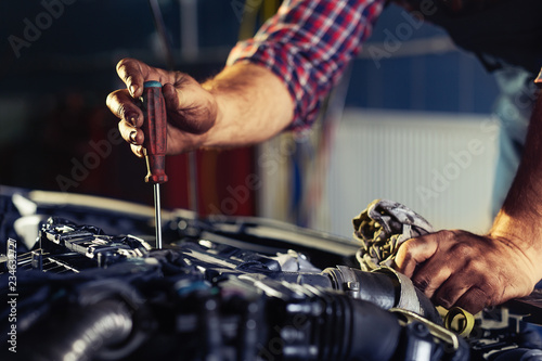 Automobile mechanic repairing car in automobile store