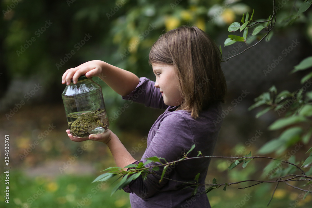 Fotografie, Obraz Child girl holding jar with frog, naturalist