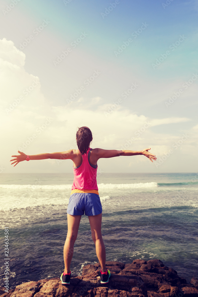 freedom woman outstretched arms on seaside cliff edge