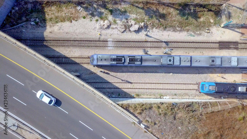 Modern passenger train leaving a train station - Aerial footage
