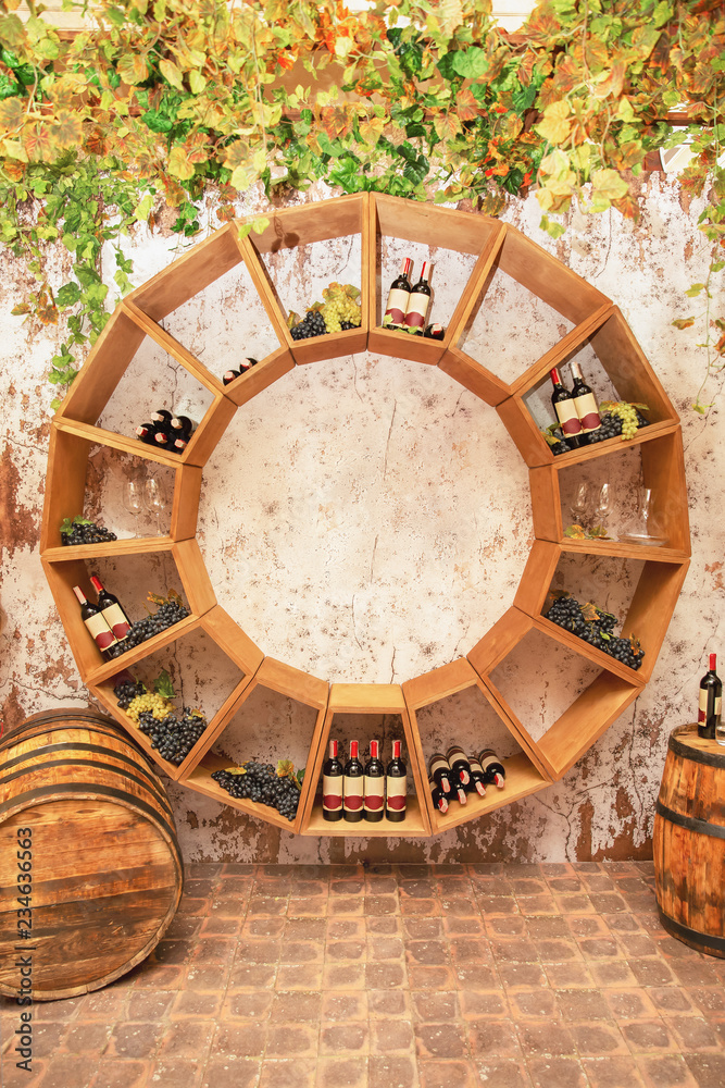 Old wine barrels, grapes, casks and bottles in wine-cellar
