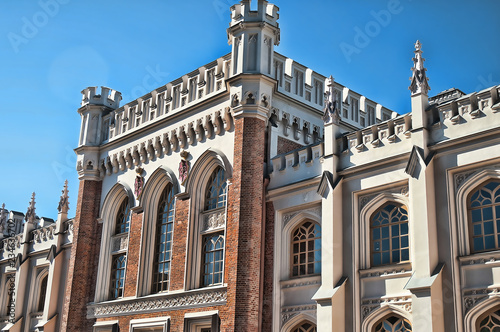 Gothic facades of a huge, trapezoid building of former court stables. The building, made in the form of a medieval fortress in the style of English Gothic photo