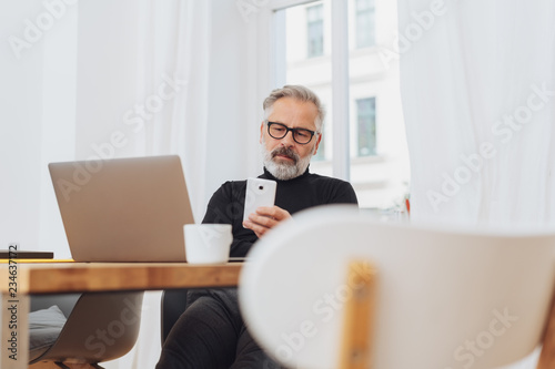 Businessman reading a message on his mobile