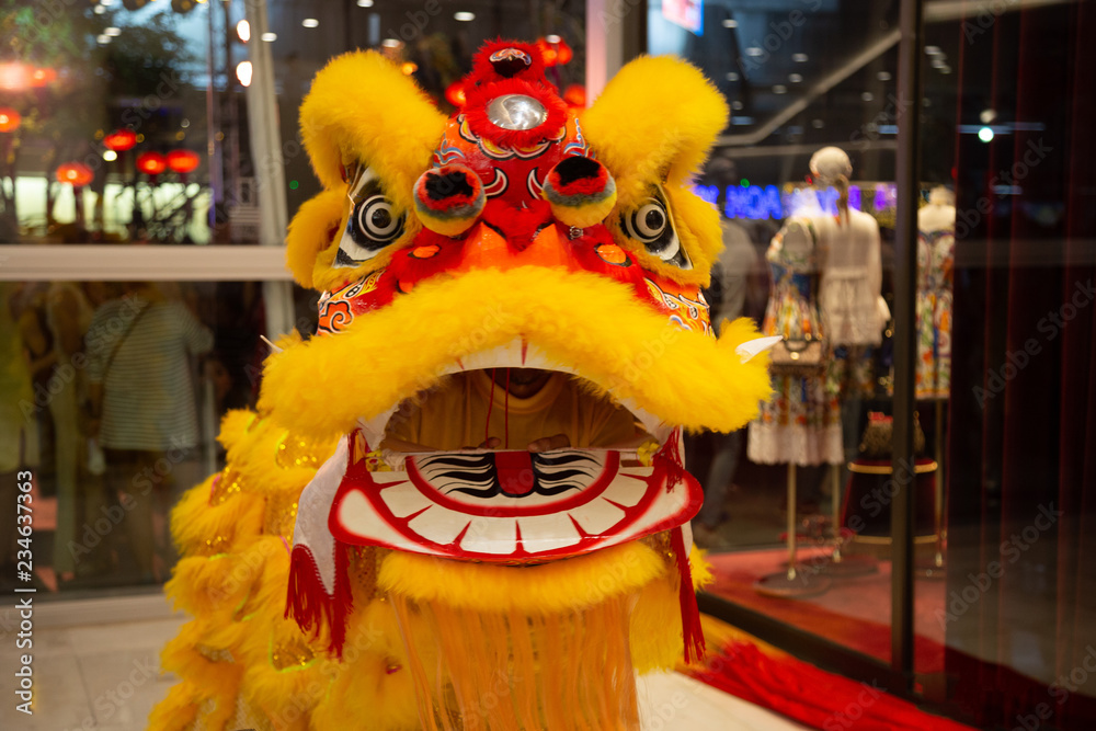 Chinese New Year lion dancing in yellow costume with mouth open.  Traditional chinese dragon dance in a shopping mall in Bangkok, Thailand.  Stock Photo | Adobe Stock