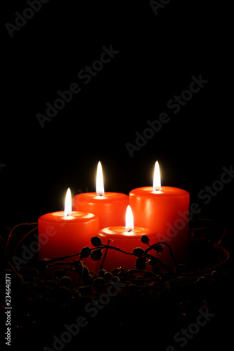 four red christmas candles with burning flames                              