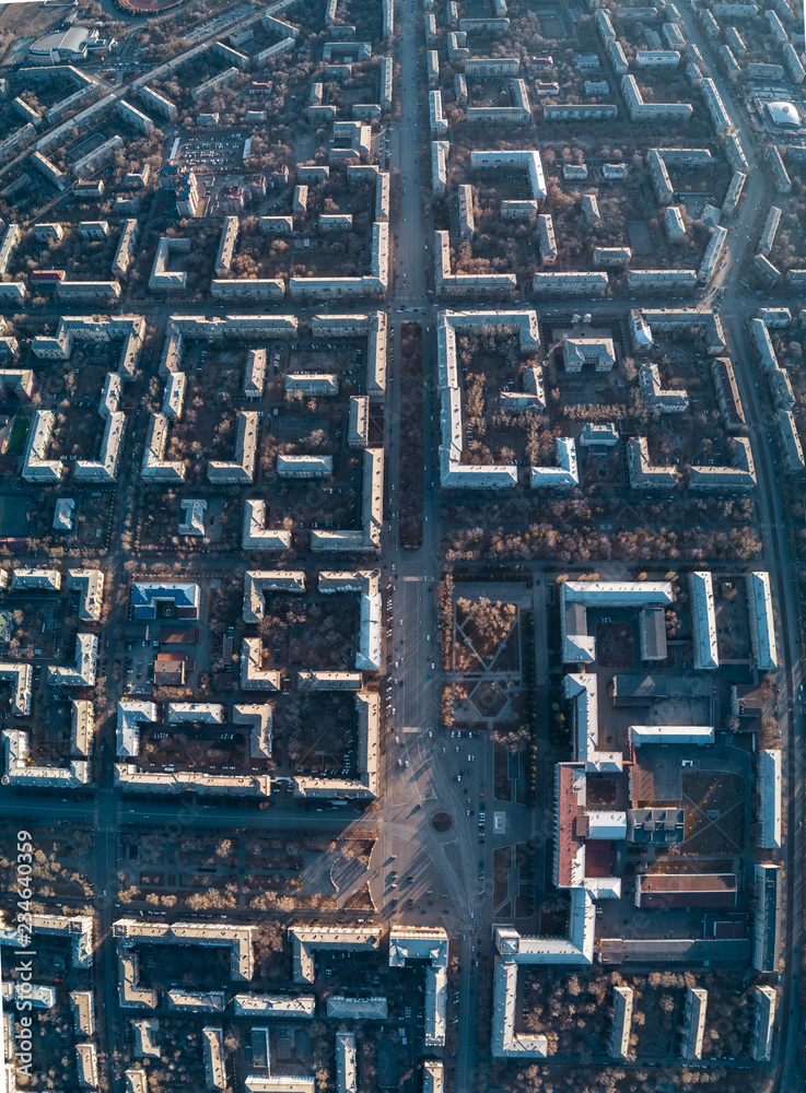 Aerial view of cityscape; top down drone shot; smooth rows of houses and streets with square in center; architectural ensembles, complexes with gardens and parks; street geometric pattern single style