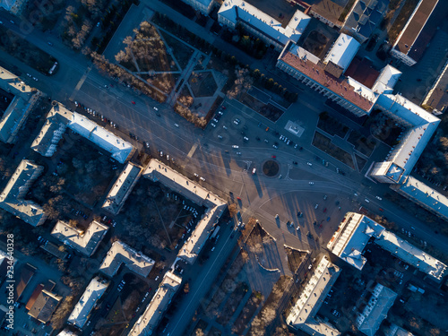 Aerial view of cityscape; top down drone shot; smooth rows of houses and streets with square in center; architectural ensembles, complexes with gardens and parks; street geometric pattern single style