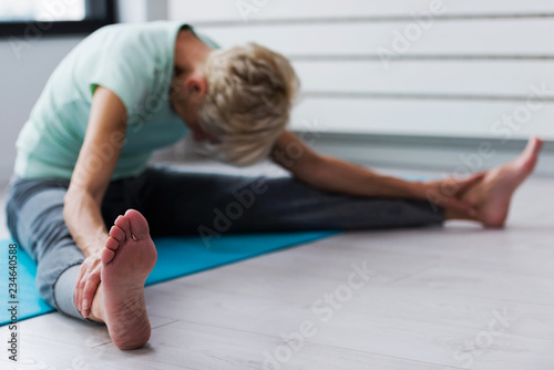 Active senior woman practicing yoga indoors. Exercises for Older Women. Yoga classes for seniors.