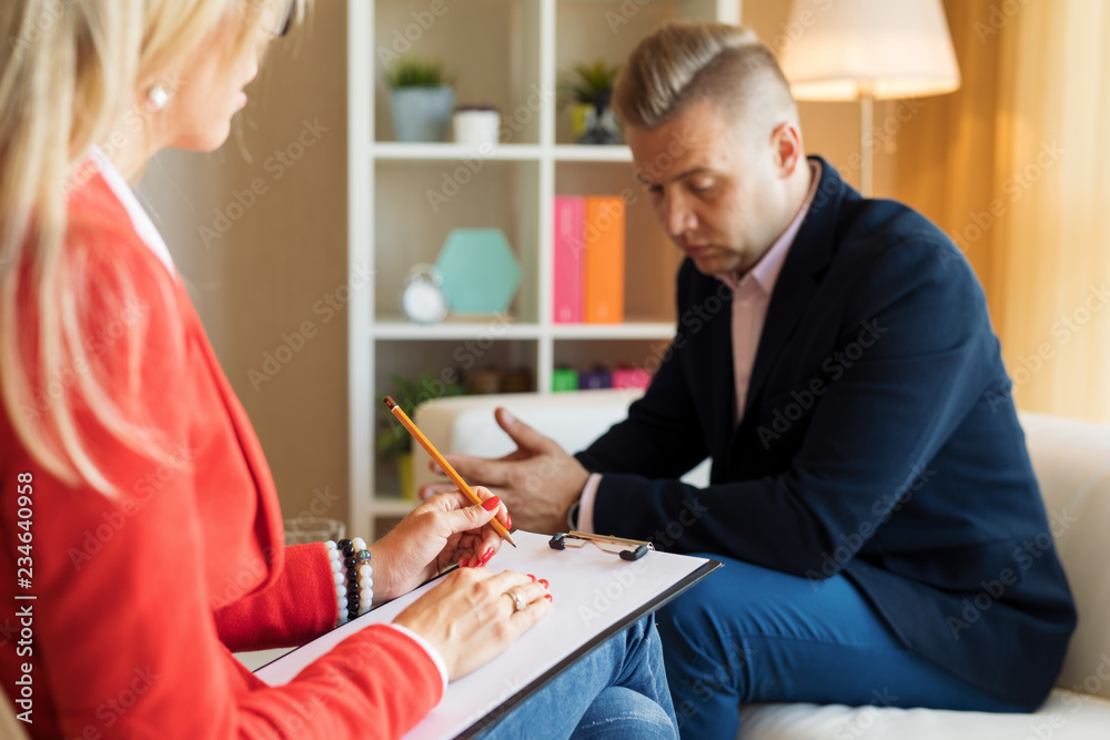 Obraz premium Young man talking with psychotherapist