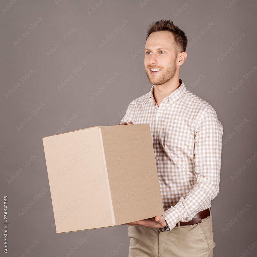 young man, holding a big packaging box, and smiling young man, holding a big packaging box, and smiling