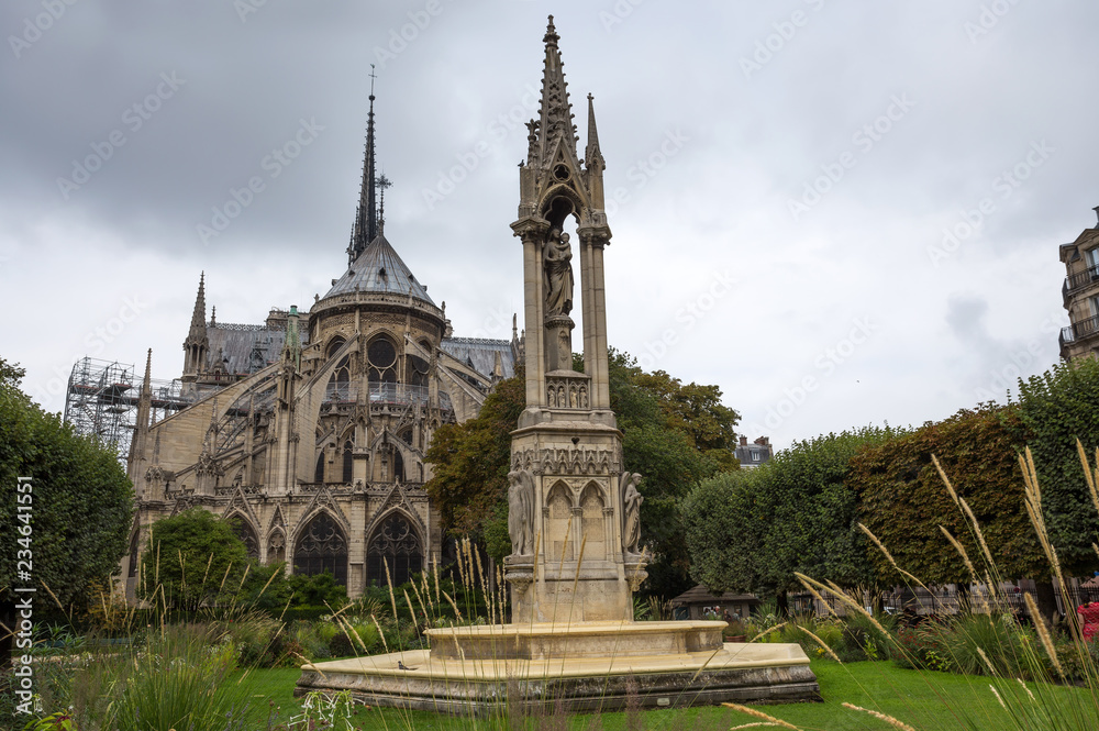 Apse of Notre-Dame de Paris and La fontaine de la Vierge from Square Jean-XXIII. Paris, France