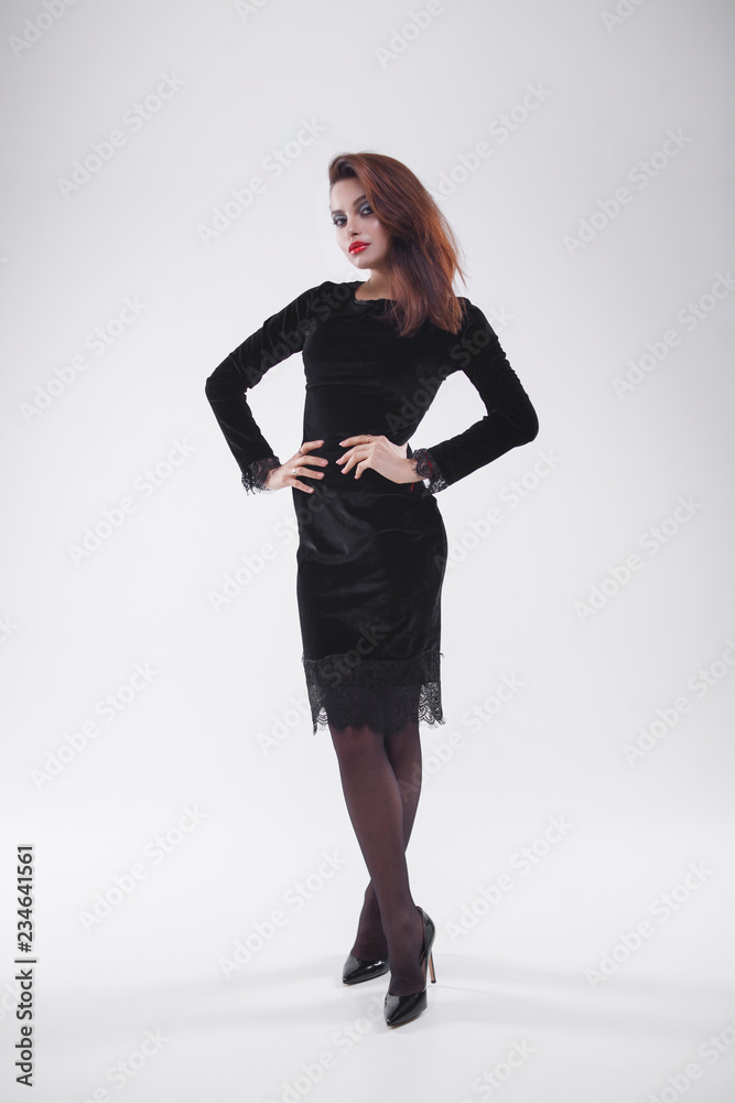 Girl alone, standing on a white background in a dress, on heels