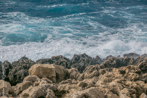 Sea waves splashing on rocky shore, marine background	