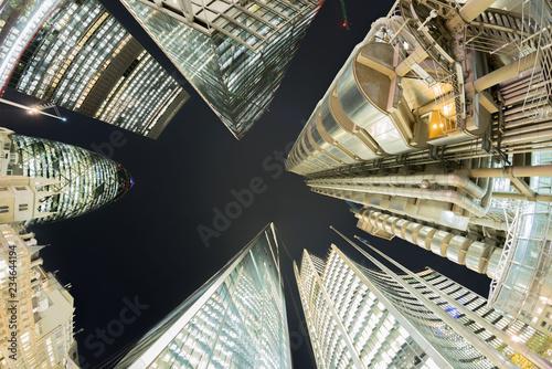 Looking directly up at London financial district skyline at night 