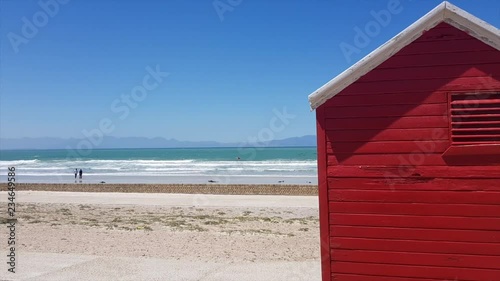 Red Cottage on Beach with couple in the background