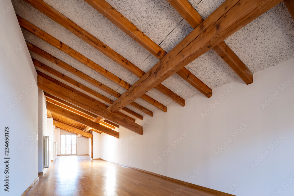 Obraz premium Large empty room with wooden beams and parquet