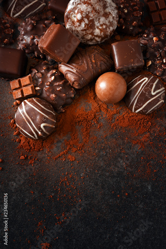 festive chocolate cookies and pralines on a slate stone slab, dark background with generous copy space, high angle view from above, vertical