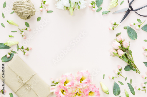 Flowers composition with gift on white pink background. Flat lay