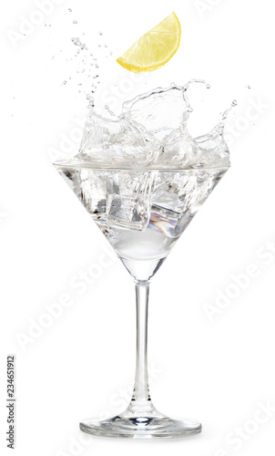 lemon slice falling into a martini cocktail splashing on white background
