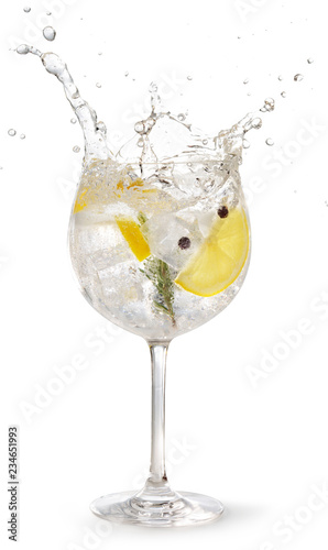 gin tonic garnished with lemon and rosemary splashing on white background