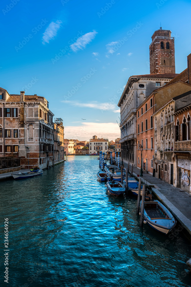 Venezia con tipico scorcio con canale e barche in ambientazione diurna
