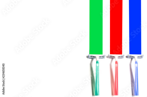 Three multi-colored razors leave colored marks photo