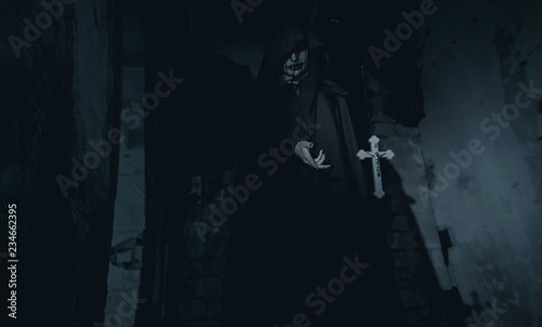 Canvas-taulu Woman is standing in a darkness next to the cross flying in the air in an image of a nun possessed by demons