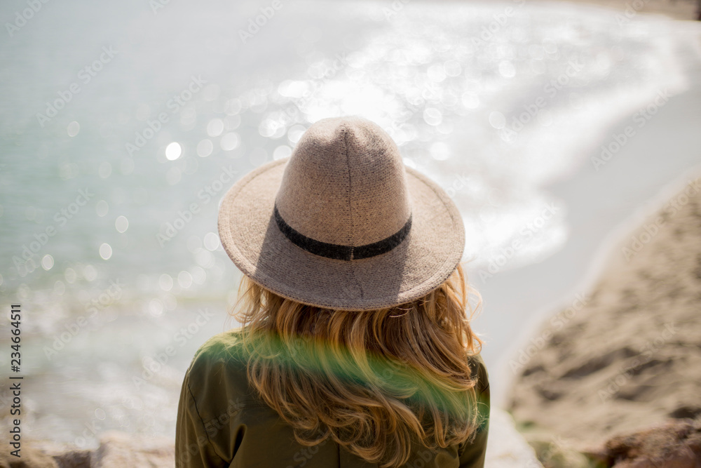 woman whit hat looking at the sea