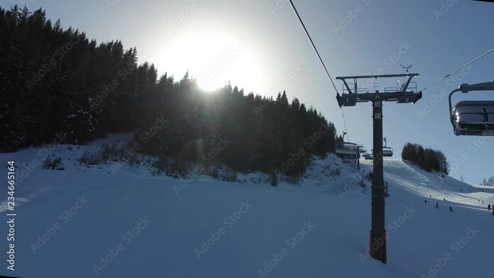 Riding up gondola sun peeping behind trees Riding up gondola sun peeping behind trees