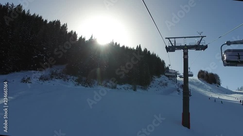 Riding up gondola sun peeping behind trees