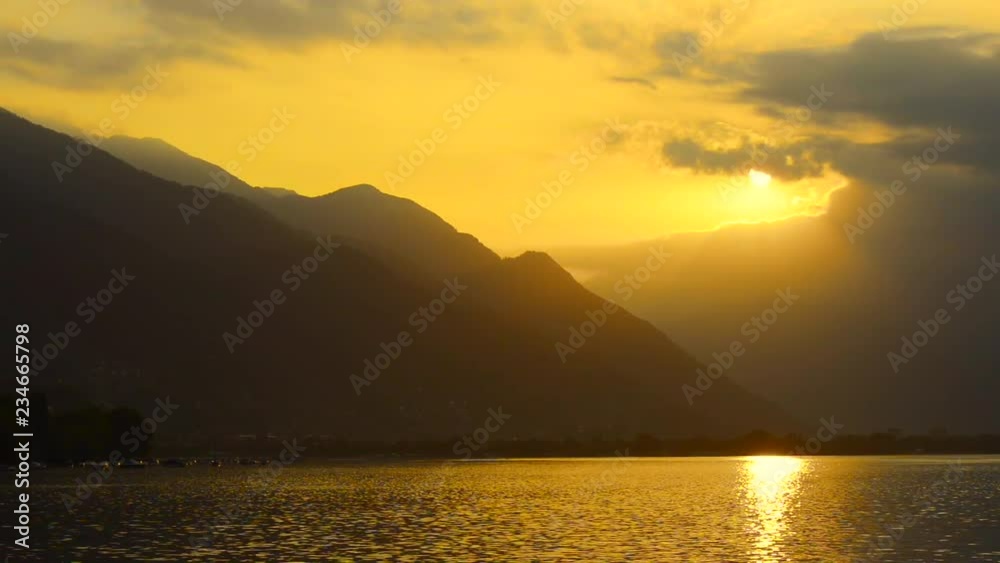 Panoramic View with Sunlight and Clouds over Alpine Lake Maggiore with Mountain in Locarno, Switzerland. Panoramic View with Sunlight and Clouds over Alpine Lake Maggiore with Mountain in Locarno, Switzerland.