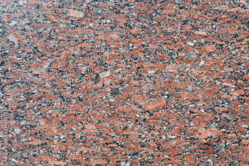 The flat surface of a natural marble or brown granite slab. On the surface there are many small cracks, streaks, stripes and dots. Background, Wallpaper or backdrop. Natural material.