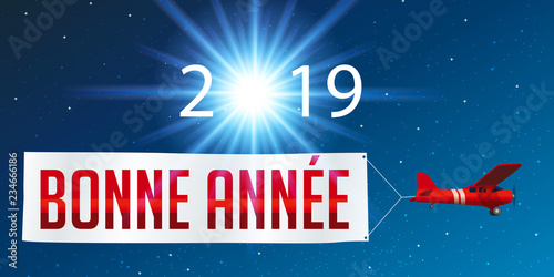 Carte de vœux 2019 montrant un avion rouge tirant une banderole blanche pour souhaiter la bonne année, devant un ciel étoilé