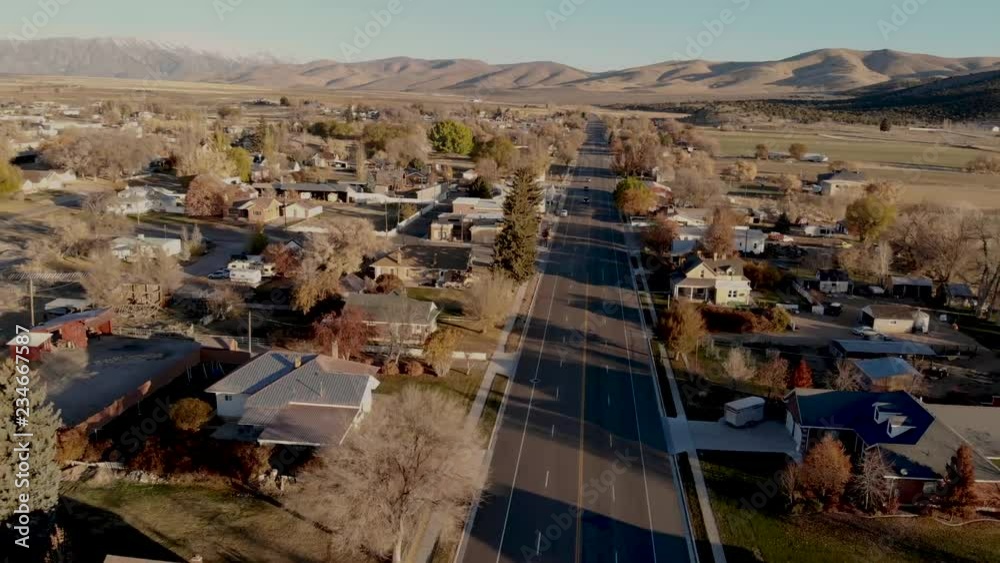 Aerial-Pulling back over Main street of a small rural mountain community on a clear autumn morning with long shadows