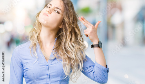 Bilde på lerret Beautiful young blonde business woman over isolated background Shooting and killing oneself pointing hand and fingers to head, suicide gesture
