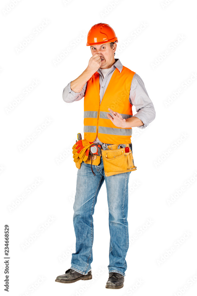 Portrait of a male builder in a helmet  looking at camera over white wall background. repair, construction, building, people and maintenance concept.