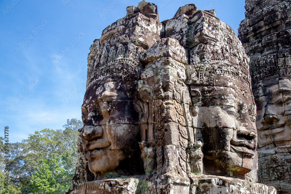 Ancient temple name Bayon with stone faces in Angkor Thom, Siem Reap, Cambodia. Bayon's most distinctive feature is the multitude of serene and smiling stone faces on the many towers.