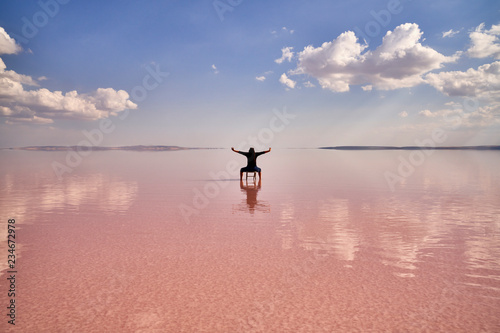 woman sitting on chair with blue sky and beautiful lake