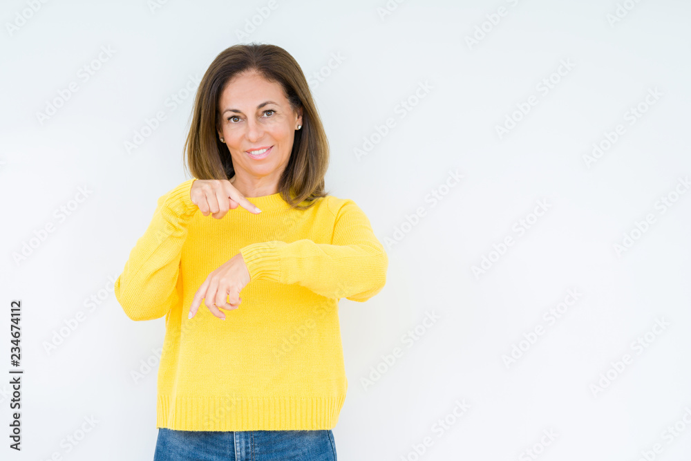 Beautiful middle age woman wearing yellow sweater over isolated background In hurry pointing to watch time, impatience, upset and angry for deadline delay Beautiful middle age woman wearing yellow sweater over isolated background In hurry pointing to watch time, impatience, upset and angry for deadline delay