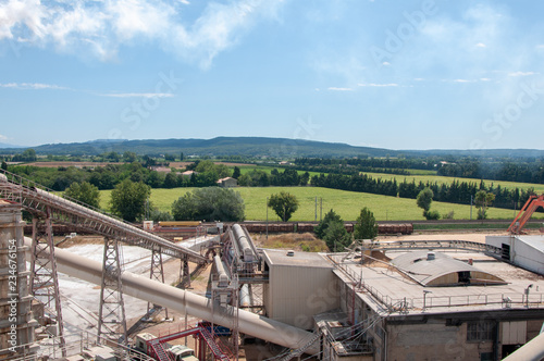 Pulp and paper mill on the background of green agricultural fields. photo