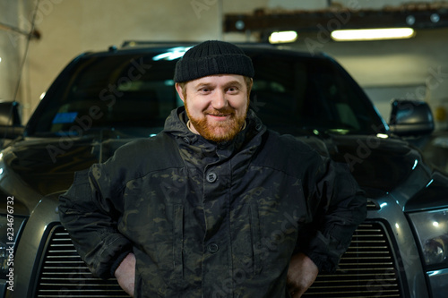 serious man with a red beard on a pickup truck © Olek